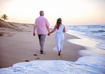 bride and groom walk on beach
