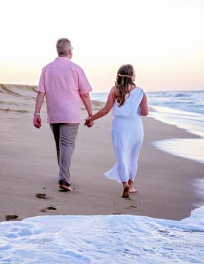 bride and groom walk on beach