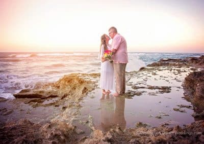 bride kissing groom on beach