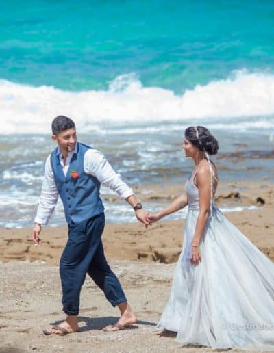 bride and groom walk on beach mexico