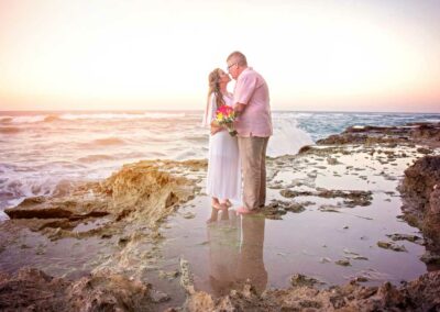 husband kiss wife on beach